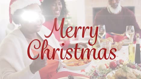 Merry-christmas-text-banner-against-african-american-woman-serving-food-while-having-dinner