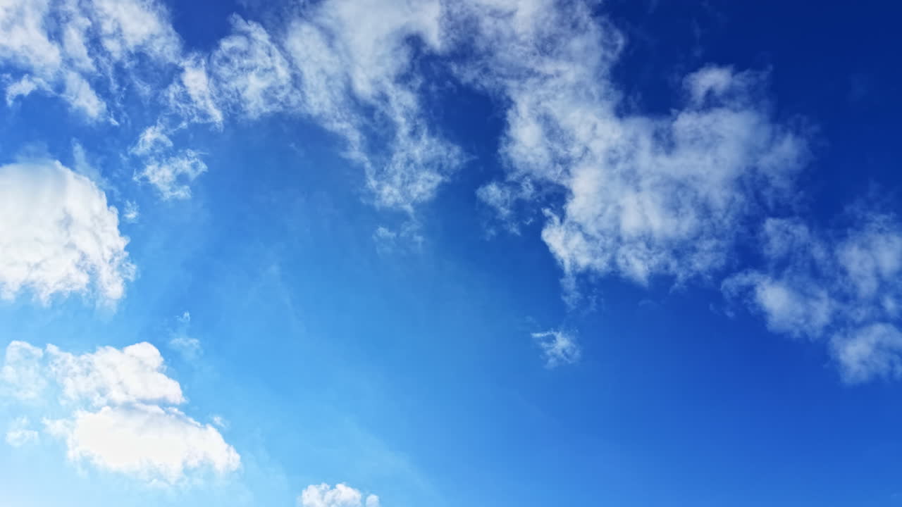 Cielo azzurro mozzafiato, impreziosito da soffici nuvole bianche in una giornata di sole, che offre una fuga tranquilla dalla frenesia della vita quotidiana