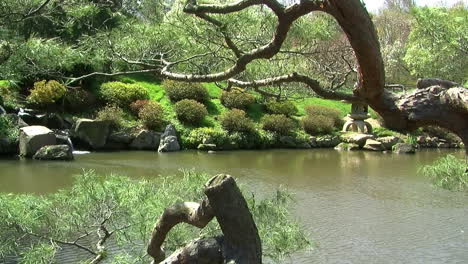 Brazos-De-Cámara-De-Derecha-A-Izquierda-En-Un-Jardín-Japonés-Con-Estanque,-Linterna-De-Piedra-Y-Cascada