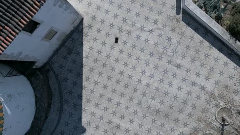 Top-down-aerial-view-of-people-walking-on-the-famous-Lisbon-town-sidewalk-in-Portugal