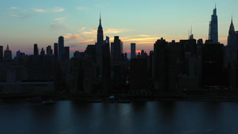 Elevación-Aérea-Dramática-E-Inclinación-Hacia-El-Legendario-Horizonte-De-Midtown-Manhattan-Al-Atardecer