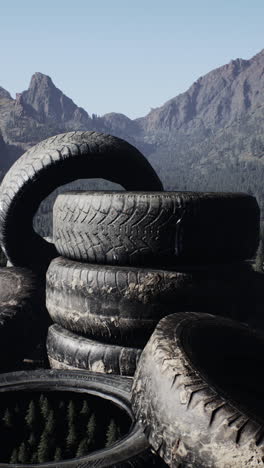 a pile of tires in front of a mountain landscape.