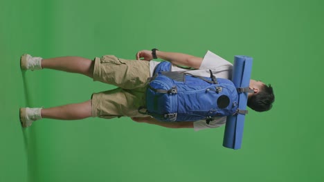 man with backpack and yoga mat on green screen