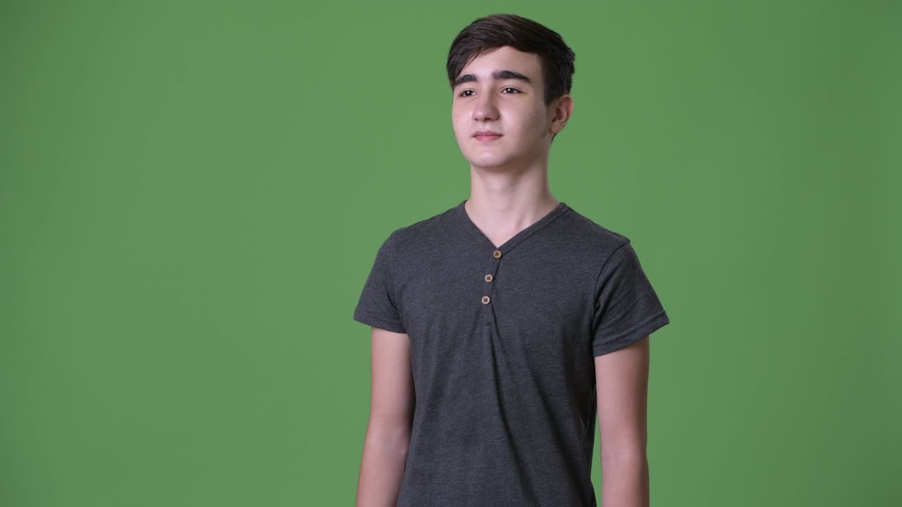 초록색 배경에 젊은 잘생긴 이란 십대 소년