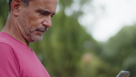 Close-up-of-senior-bearded-man-looking-at-mobile-screen