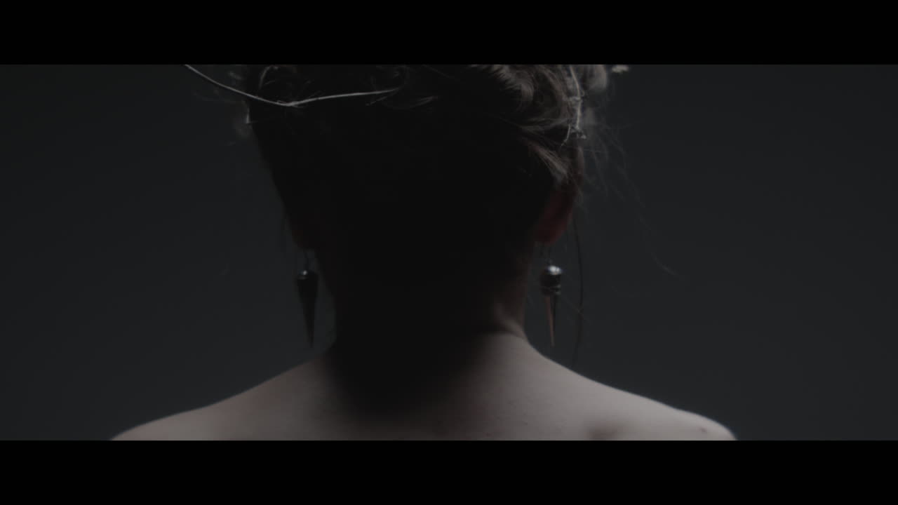 A woman dressed as mother nature moves slowly in a dance-like motion