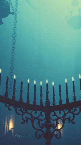 menorah with lit candles in a dark church