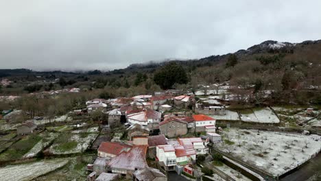 pueblo nevado con vegetación en invierno bajo un cielo nublado en picornio, en galicia