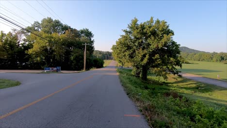 Biker's-frontal-point-of-view-going-down-hill-on-a-country-road