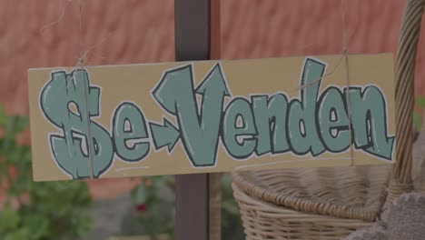 static shot of a colombian sign swinging in the wind at a farmer's market