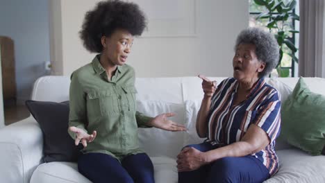 Sad-african-american-adult-daughter-and-senior-mother-having-disagreement-at-home,-slow-motion