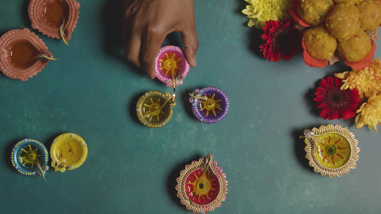 Overhead Shot Of Man Lighting Diya Oil Lamps Celebrating Festival Of Diwali