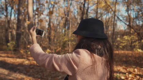 woman taking selfie in autumn forest