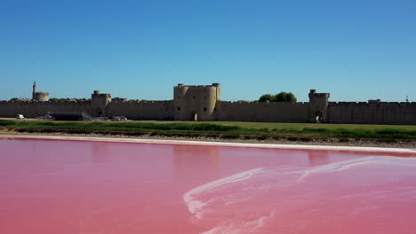 aigues-mortes 是一個歷史悠久的城市,位於法國卡馬爾古省,在一個陽光明<unk>的夏天,靠近一個粉紅色的盐湖.