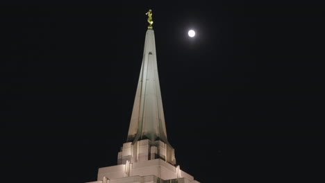 top of lds mormon temple church building at night with moon in gilbert, arizona | statue of the angel moroni