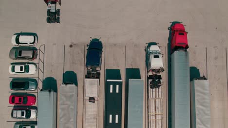 beautiful aerial of a red semi bobtail backing up to a reefer - dry van trailer to hook it up