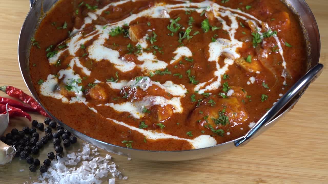 disparo giratorio de un curry malayo fresco en un plato balti listo para ser servido