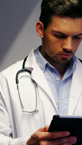 doctor using digital tablet in corridor