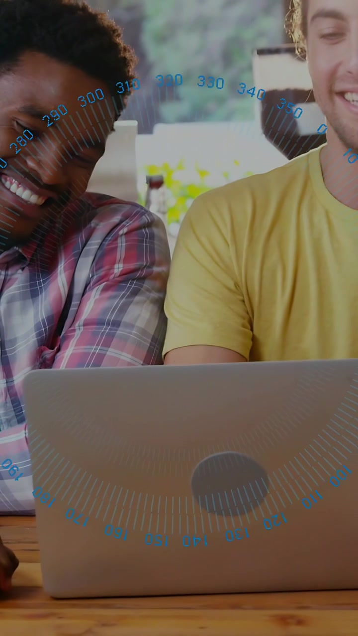 Vídeo vertical: Dois homens inclinados sobre um laptop, olhando e fazendo números HUD azuis surgirem para análise