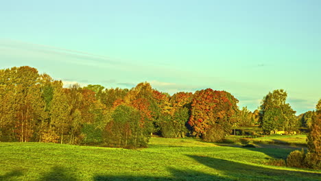 Lapso-De-Tiempo-Del-Amanecer-Golpeando-Un-Bosque-Y-Campos-Verdes-En-Letonia