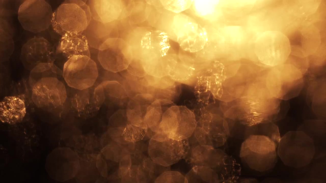 Gyllene bokeh-ljusläckor på svart bakgrund