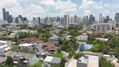 contrasting bangkok: quiet homes and trees set against soaring skyscrapers.
