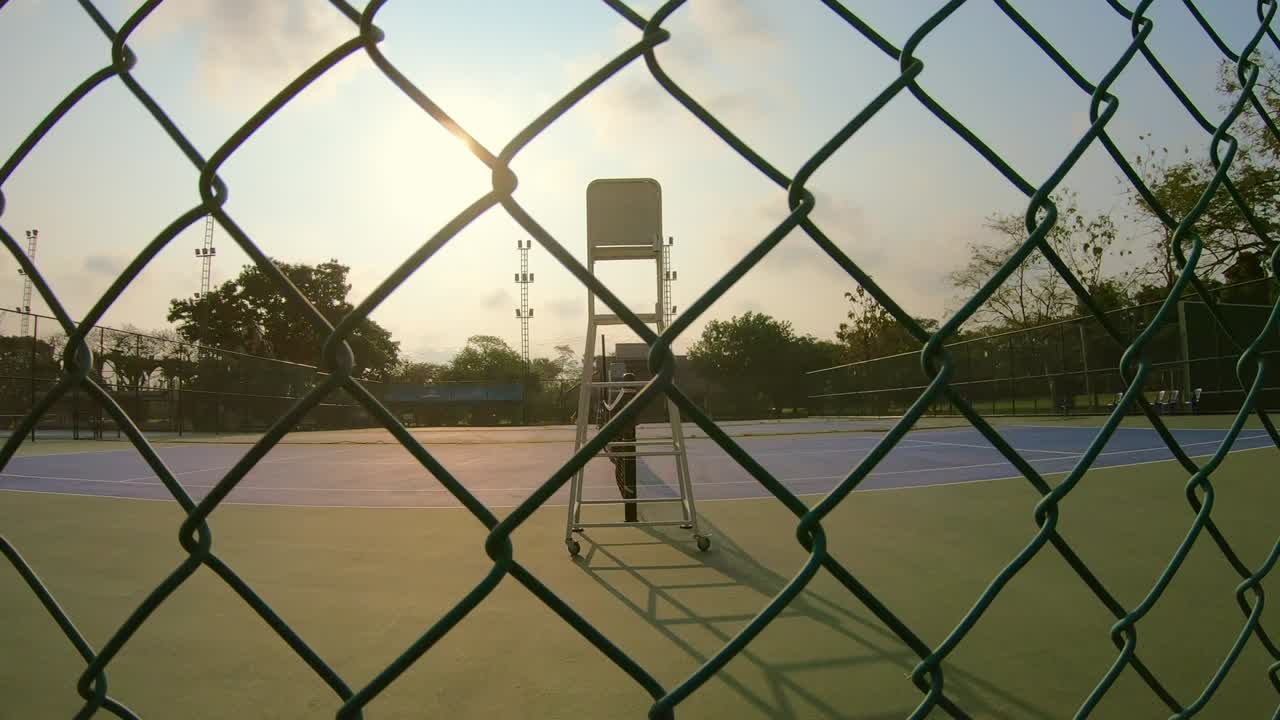 una cancha de tenis vacía por la mañana con el amanecer
