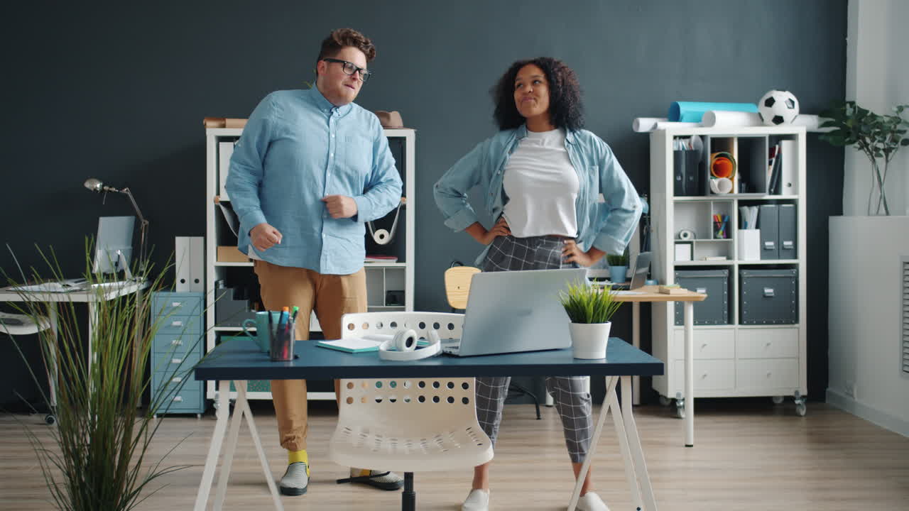 Two people dancing in an office