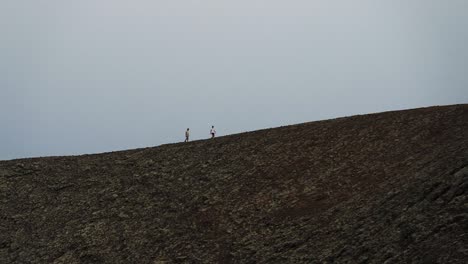 two men walking in a volcano crater in slow motion