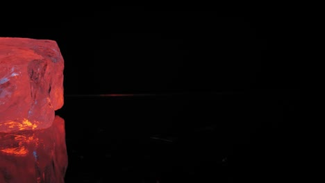 검은색 배경의 따뜻한 주황색 스튜디오 조명 아래 수정처럼 맑은 석영, 매끄러운 팬은 반사 및 눈에 띄는 파란색 하이라이트를 나타냅니다.