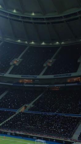 crowd of soccer fans filling stadium grandstands cheering during a professional match, creating an electrifying atmosphere under the bright stadium lights