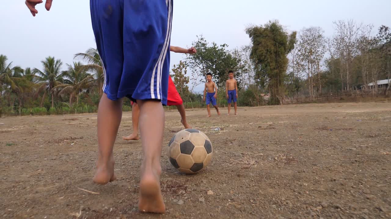Boys Playing Soccer in a Rural Field