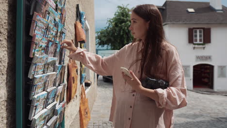 woman looking at postcards in a european town