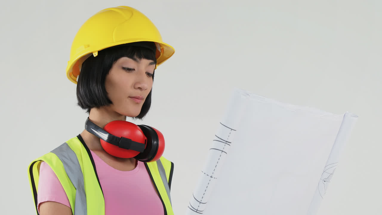 회색 배경 에 대한 청사진 을 들고 있는 여성 건축가 4k 4k