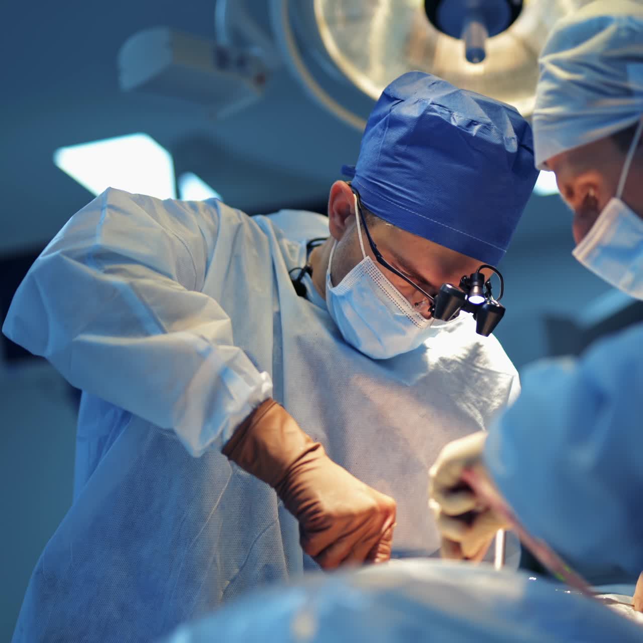 Experienced medics neurosurgeons provide difficult operation with special equipment in modern clinic room with bright light