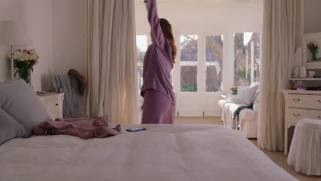 beautiful young woman practicing ballet dancing in bedroom rehearsing dance on weekend morning wearing pajamas