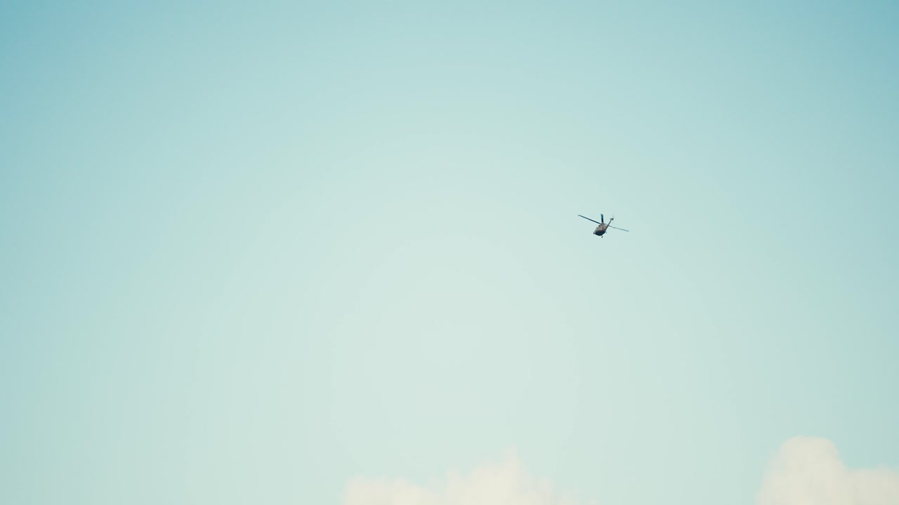 하늘에서 날아다니는 헬리 ⁇ 터의 느린 움직임  ⁇ 이 오른쪽으로 돌아갑니다.