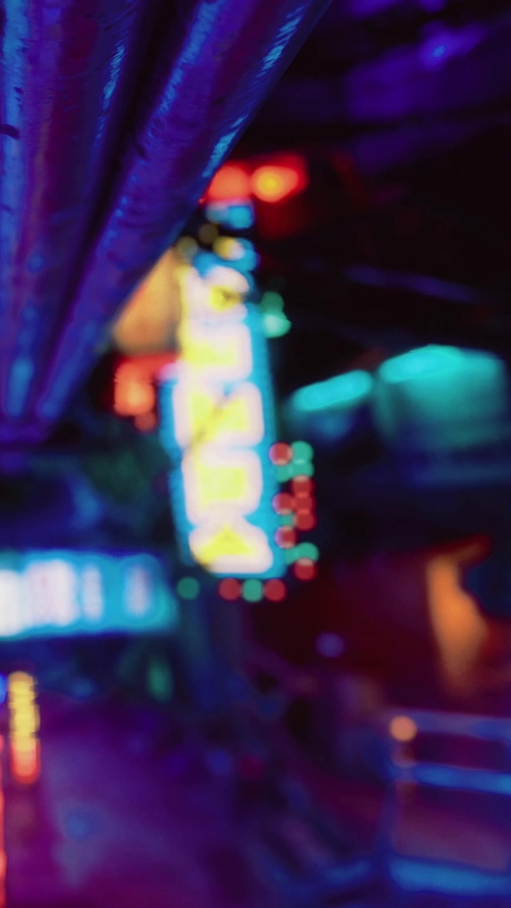 Bright neon lights shine in a dark alley during late night hours