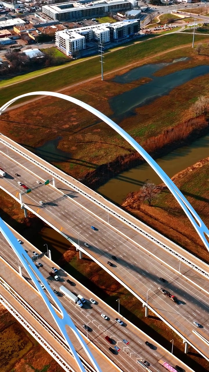 The Margaret McDermott Bridge over the Trinity River in Dallas, Texas. One line of the bridge is full of moving cars. Top view. Vertical video