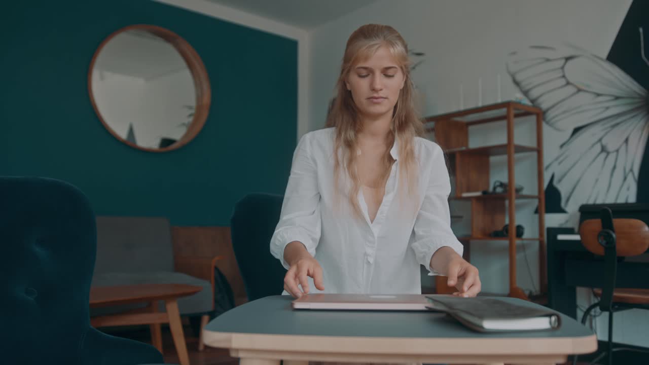 Woman Working on Laptop in a Cozy Cafe