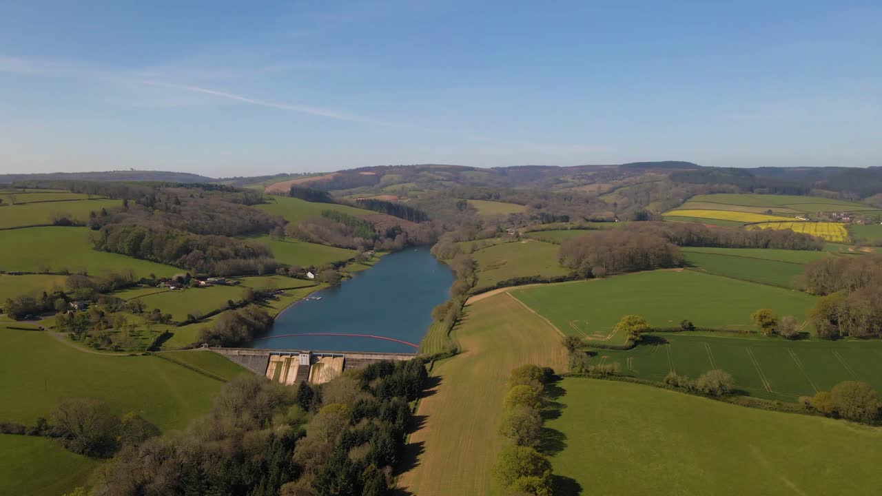 Volo 4K sopra il bacino idrico di Hawkridge, drone che avanza sopra l'albero verde di fronte alla diga, 60fps.