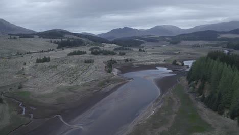 Flight-over-a-river-with-mountains-at-the-horizon