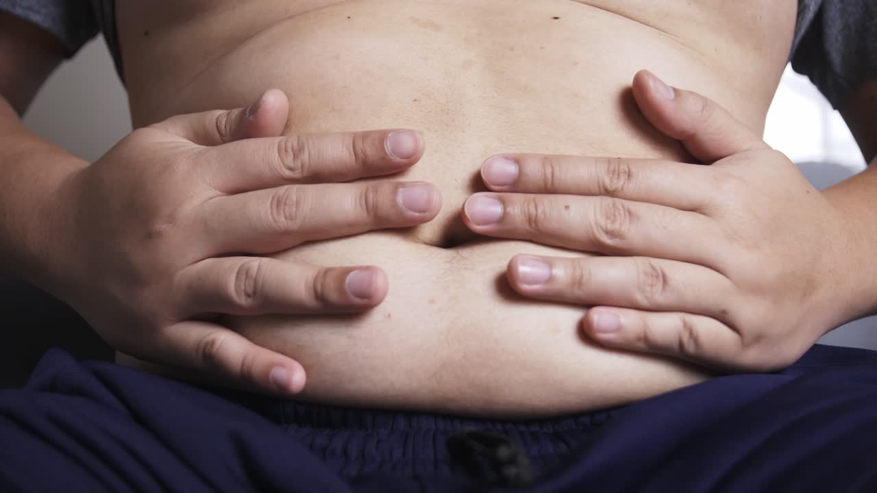 el hombre está presionando su mano sobre su estómago debido a un dolor abdominal persistente
