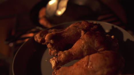 barbecuing chicken drumsticks, cooked chicken legs off campsite bbq, closeup