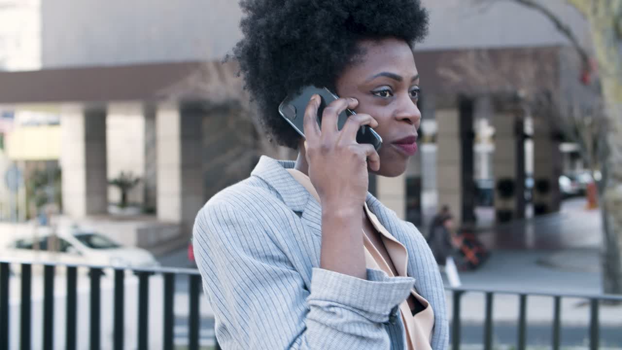 joven empresaria segura de sí misma que se comunica a través de un teléfono inteligente