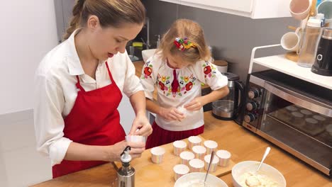 mother and daughter baking cupcakes together