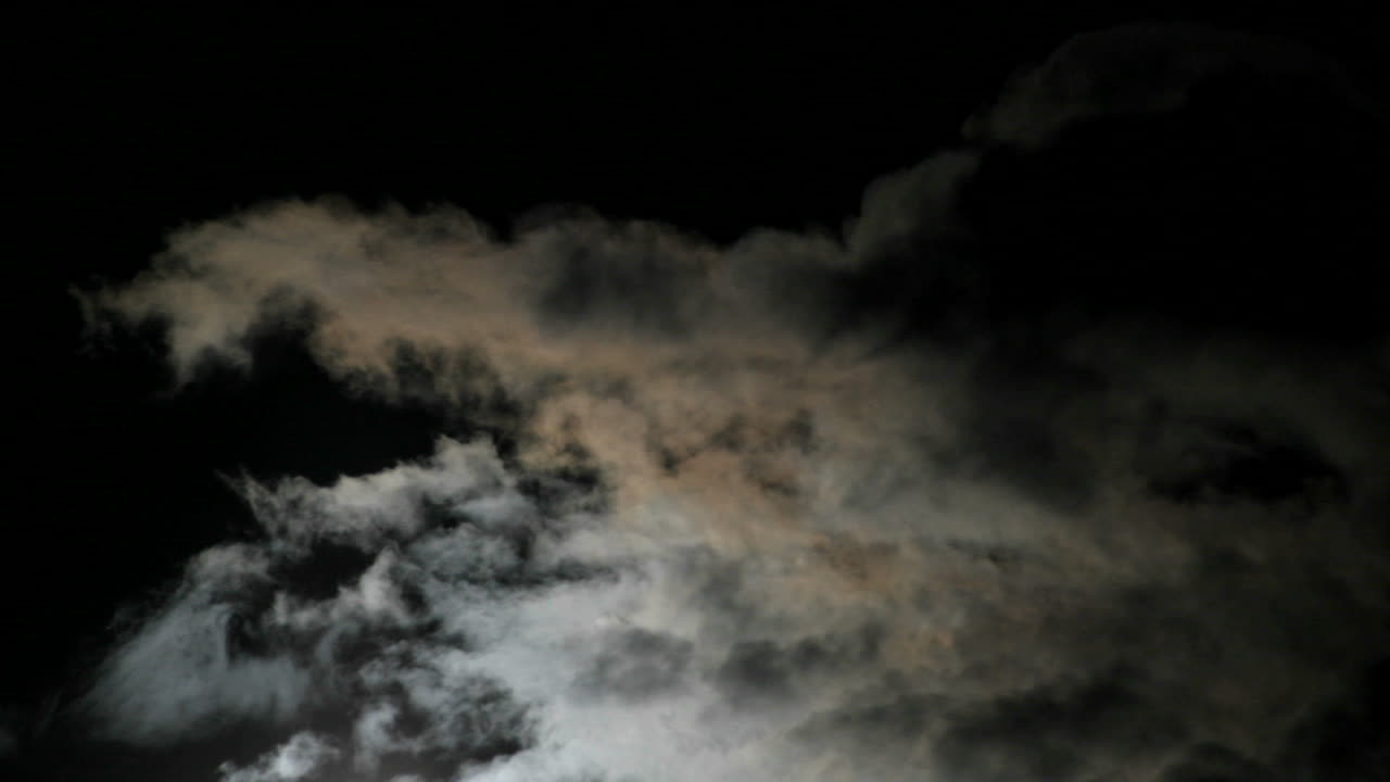 밤하늘에 빠르게 움직이는 구름 위로 밝은 보름달이 떠오른다