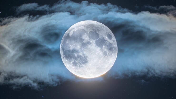 Sich verschiebende, vom Wind getriebene blau-graue Wolken enthüllen einen zentrierten Vollmond, schwache Sterne bilden einen Hof.