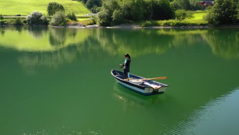 woman on the boat catches a fish on spinning in norway.