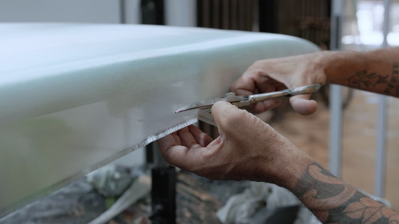 hombre irreconocible cortando película en la tabla de surf